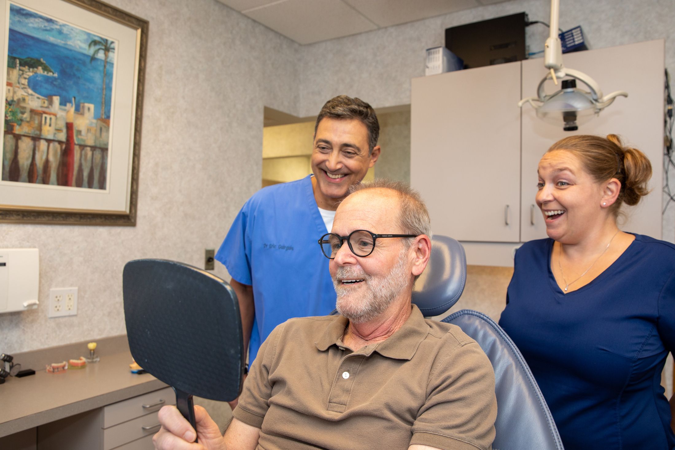 Dr. Guirguis smiling with a patient in a mirror.